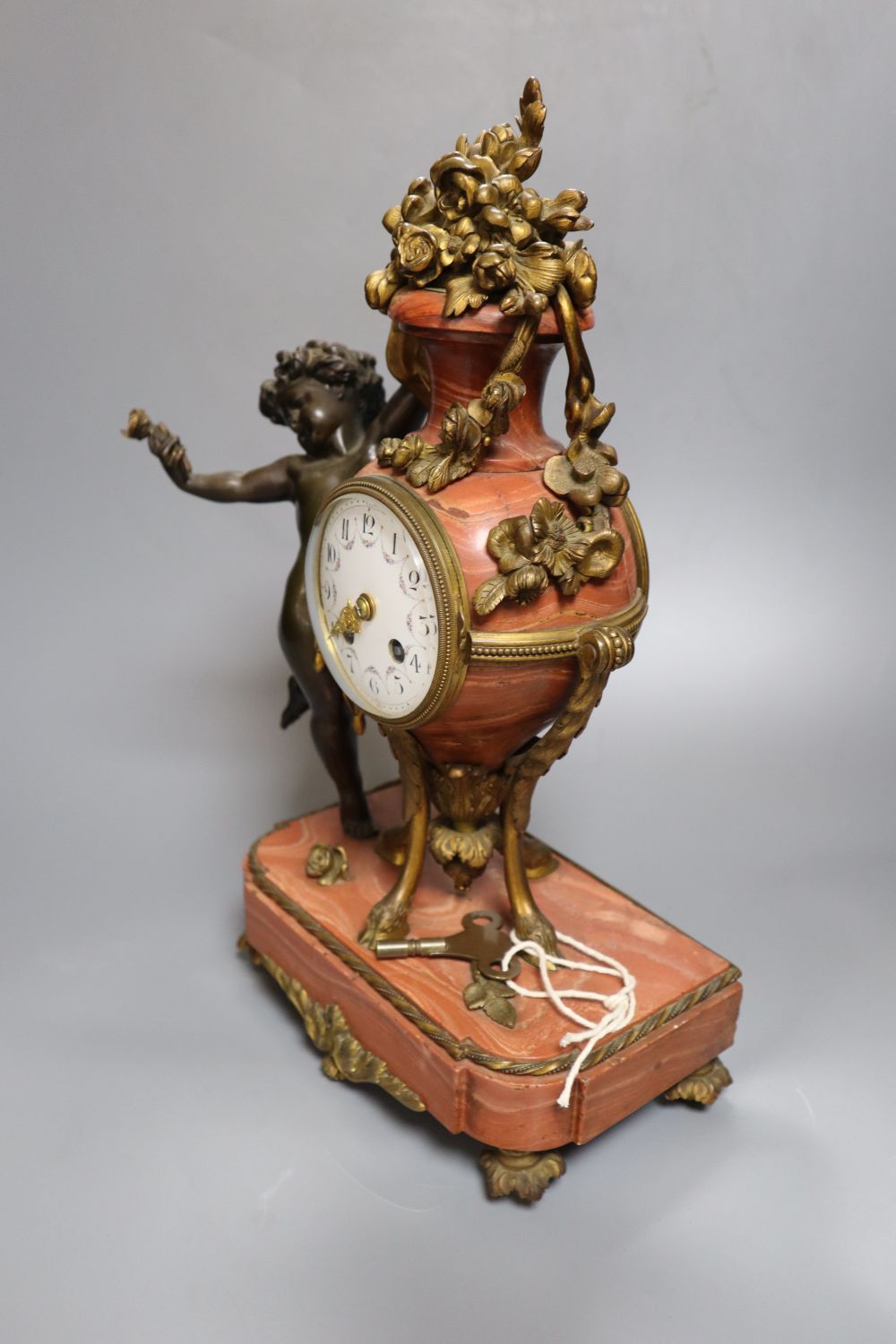 A 19th century French ormolu mounted rouge marble mantel clock, cast with putti, height 36cm